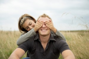 Playful couple covering eyes.